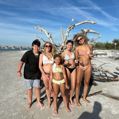 a group of people on a beach posing for the camera
