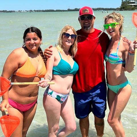 a group of people standing next to a body of water