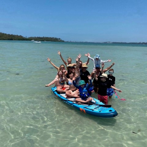 a group of people riding on the back of a boat in the water
